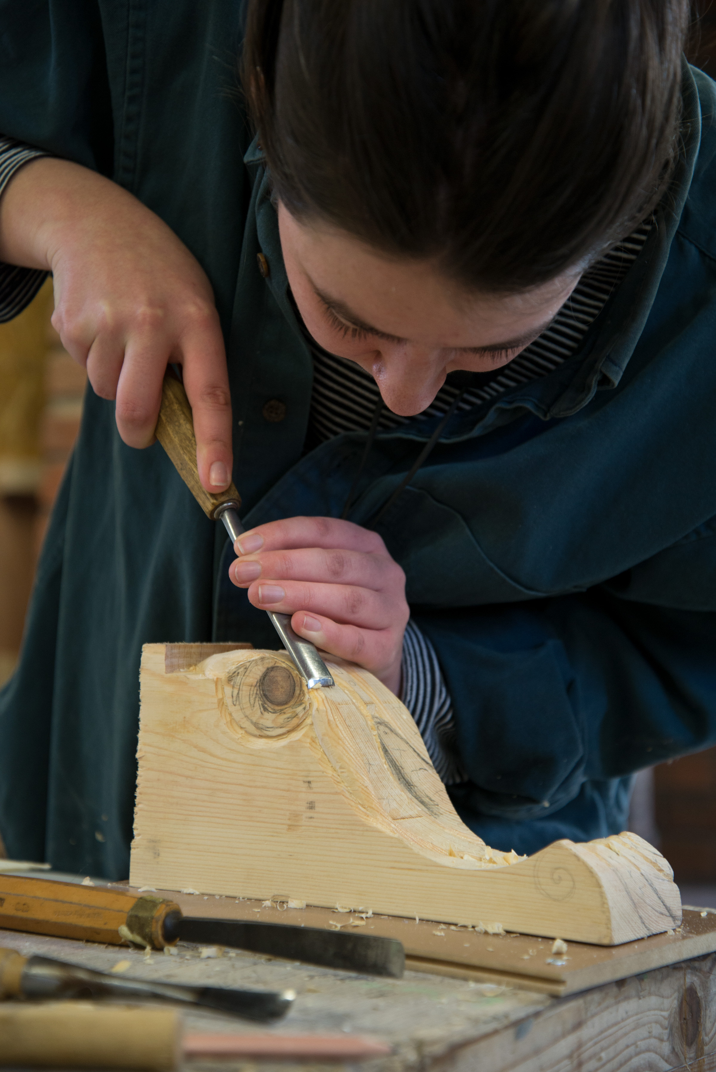 Image of a woman carving a piece of wood