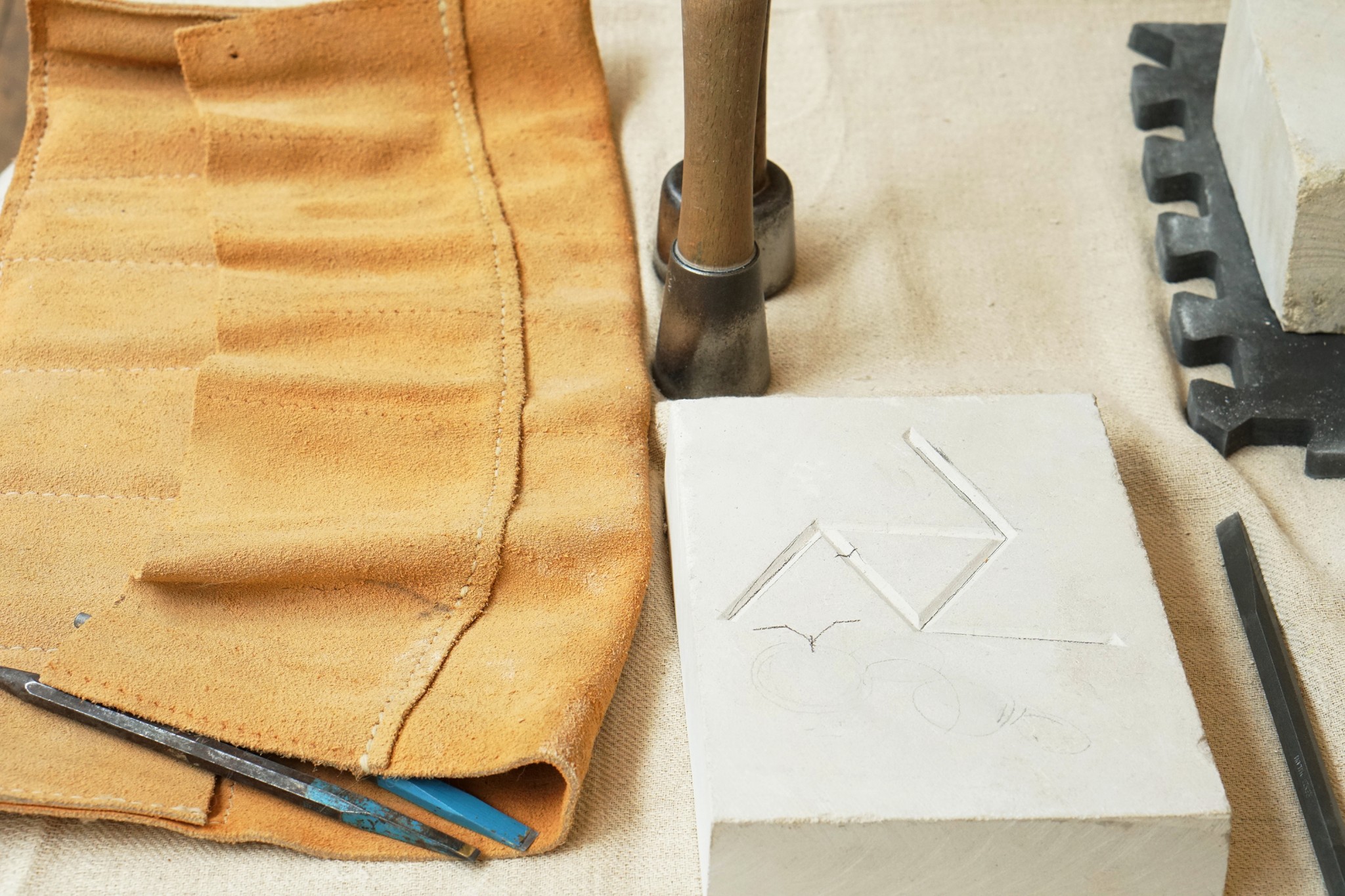 Close up image of tools and a carved block of stone