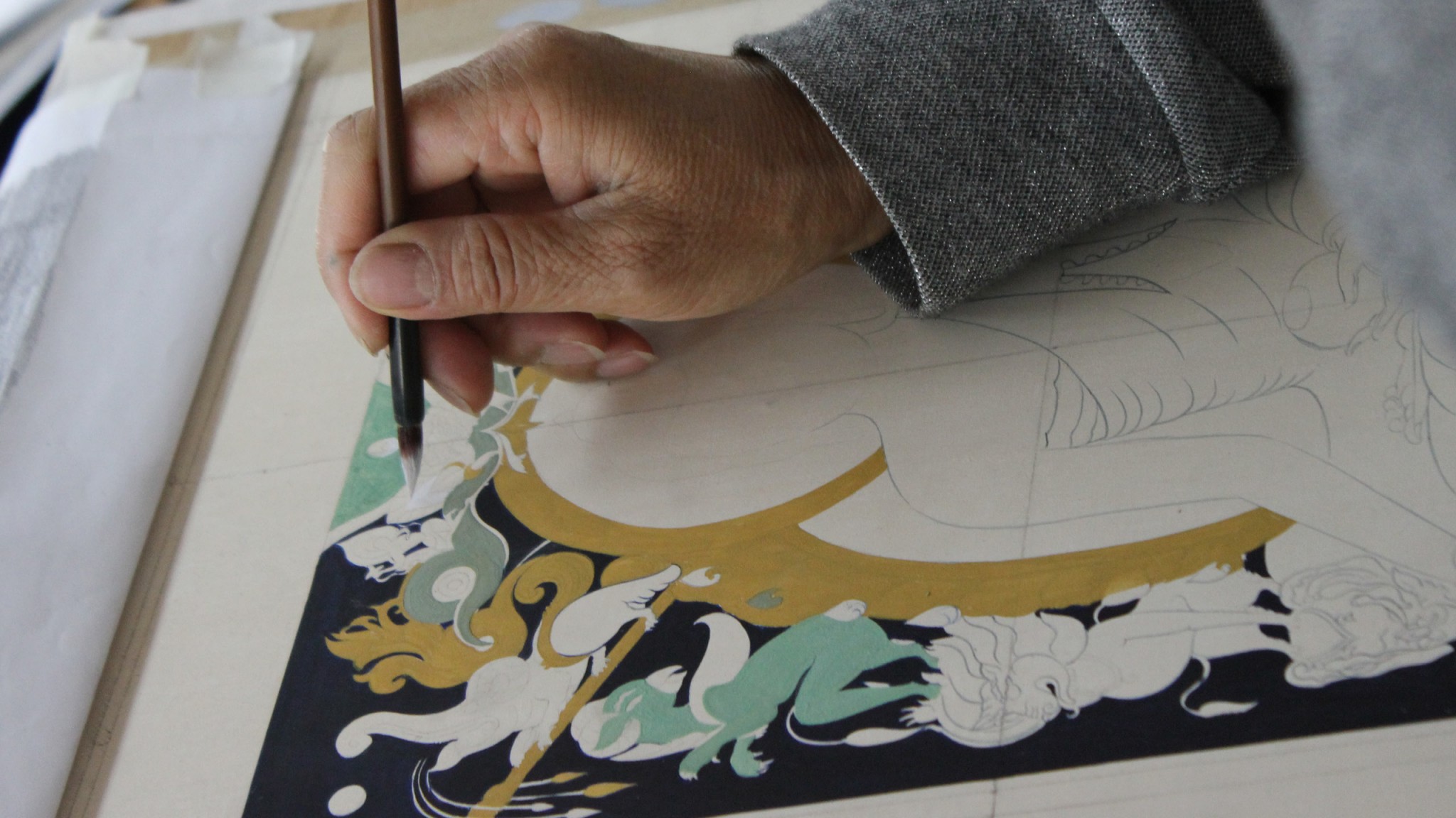 Image of a student painting with a traditional brush