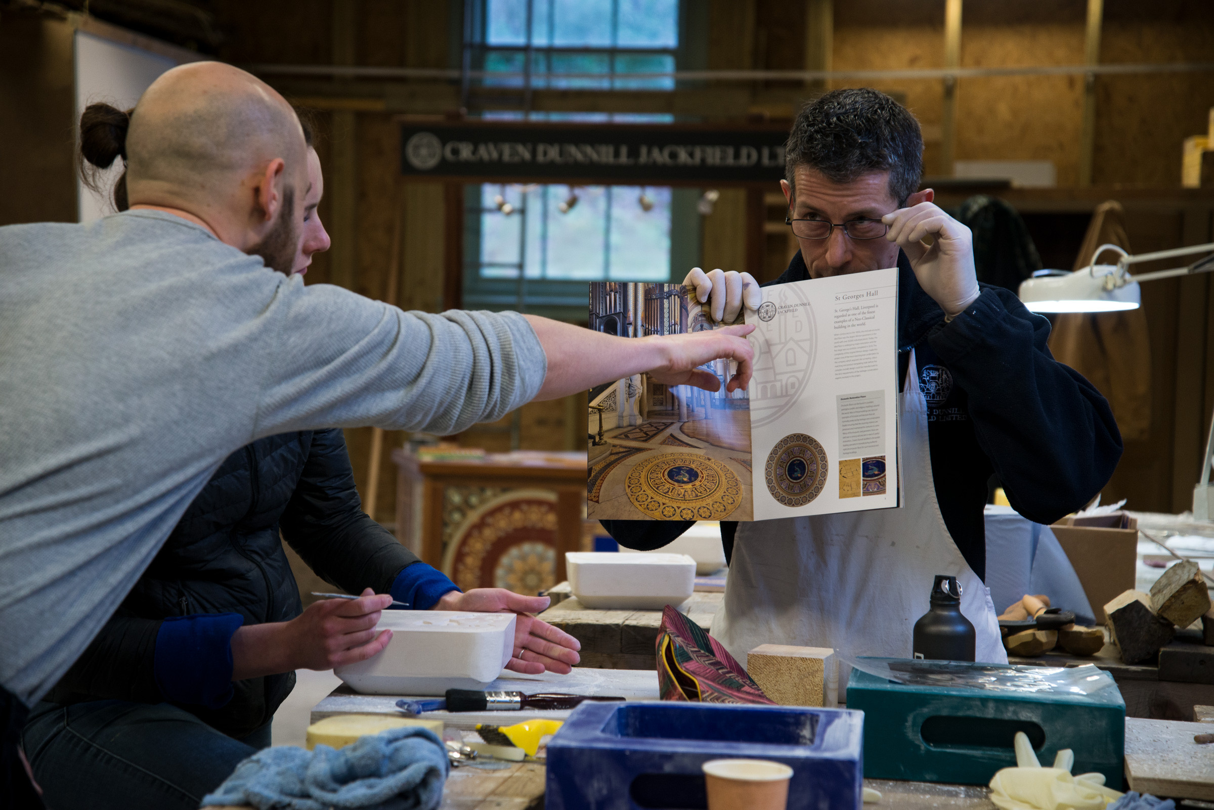 Image of three people looking at a book