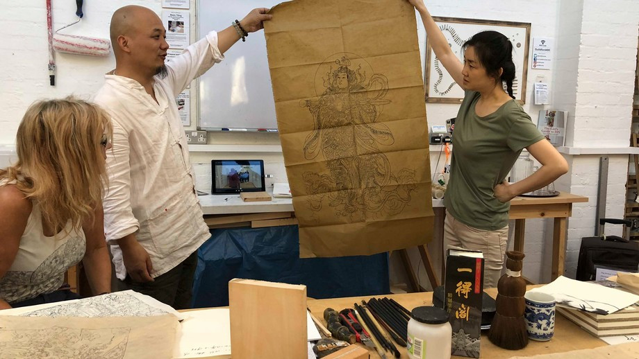 Image of two people holding a sketch