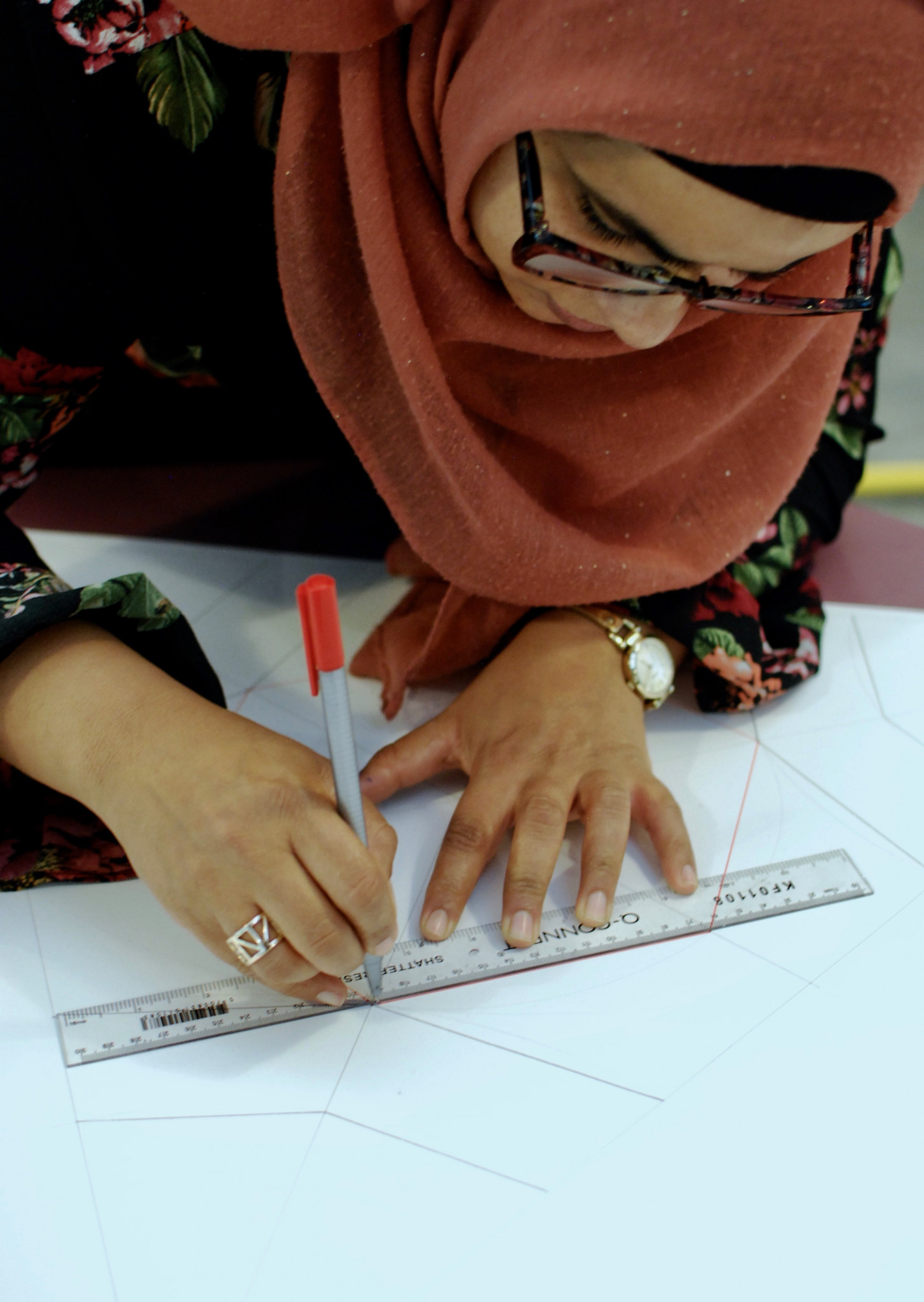 A photo of woman drawing using a ruler